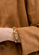 Bracciale rigido dorato con design ondulato